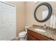 Cozy half bath features granite countertop vanity, a decorative mirror, and is perfect for guests at 11206 Coventry Grove Cir, Lithia, FL 33547
