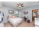 This bedroom provides neutral-colored carpet, a ceiling fan, and a bed with an ensuite bathroom at 11206 Coventry Grove Cir, Lithia, FL 33547