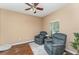 Cozy living room features two comfortable armchairs, a ceiling fan, hardwood floors and a natural light at 11206 Coventry Grove Cir, Lithia, FL 33547