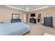 Carpeted main bedroom with tray ceiling, TV, fireplace, and furniture at 11206 Coventry Grove Cir, Lithia, FL 33547