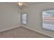 Bright bedroom featuring neutral walls, carpeted floors, a ceiling fan, and two windows with natural light at 11726 S Stone Ln, Riverview, FL 33569