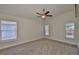 Bright bedroom with neutral walls, plush carpet, and ample natural light from two windows at 11726 S Stone Ln, Riverview, FL 33569