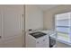 Convenient laundry room featuring a modern washer and dryer, a window, and a door for easy access at 11726 S Stone Ln, Riverview, FL 33569