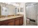 Double vanity bathroom with granite counters, warm wood cabinetry, and a separate room for the toilet and shower at 11802 Twilight Darner Pl, Riverview, FL 33569