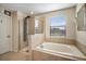 Bright bathroom featuring a glass shower enclosure and separate soaking tub at 11802 Twilight Darner Pl, Riverview, FL 33569
