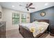 Serene bedroom with natural light, two windows, a ceiling fan, and a comfortable bed with decorative pillows at 11802 Twilight Darner Pl, Riverview, FL 33569