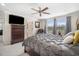 Comfortable bedroom with a ceiling fan, gray curtains, plush bedding, and a large dresser with a TV at 11802 Twilight Darner Pl, Riverview, FL 33569