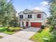 Charming two-story home with red accents, manicured lawn, and ample driveway space at 11802 Twilight Darner Pl, Riverview, FL 33569