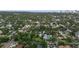 This aerial view shows the property surrounded by greenery, other homes, and the distant waterfront in sight at 1211 14Th N St, St Petersburg, FL 33705