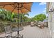 A relaxing back deck with outdoor furniture, perfect for entertaining, surrounded by tropical trees and blue skies at 1211 14Th N St, St Petersburg, FL 33705