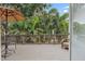 Relaxing back deck with a patio table, umbrella, and comfortable chair, with a beautiful tropical landscape view at 1211 14Th N St, St Petersburg, FL 33705