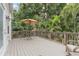 The wooden back deck features patio furniture, an umbrella, and a beautiful tropical view, with an open door at 1211 14Th N St, St Petersburg, FL 33705