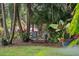 Landscaped backyard oasis with seating bench amidst tropical plants and greenery at 1211 14Th N St, St Petersburg, FL 33705