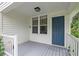 Inviting front porch with a blue door, white siding, and a view of lush tropical plants at 1211 14Th N St, St Petersburg, FL 33705