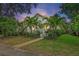 Charming home with mature tropical landscaping, lush green lawn and a welcoming walkway leading to the front porch at 1211 14Th N St, St Petersburg, FL 33705