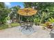 Outdoor patio featuring stone flooring, seating area with umbrella, and lush landscaping at 1211 14Th N St, St Petersburg, FL 33705