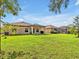 Large backyard featuring covered patio, lush lawn, screened-in patio, and space for activities at 12428 Chaya Ct, Spring Hill, FL 34610