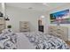 Cozy bedroom design with television, dressers, and attached bathroom at 12428 Chaya Ct, Spring Hill, FL 34610