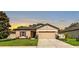 Charming one-story home featuring a well-manicured lawn, neutral tan paint, and a two-car garage at 12428 Chaya Ct, Spring Hill, FL 34610