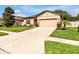 Charming one-story home featuring a well-manicured lawn, neutral tan paint, and a two-car garage at 12428 Chaya Ct, Spring Hill, FL 34610