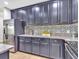 Updated kitchen featuring sleek, dark cabinetry, granite countertops, stainless steel appliances, and designer tile backsplash at 12428 Chaya Ct, Spring Hill, FL 34610