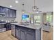 Modern kitchen with granite counters, center island, stainless appliances, stylish pendant lighting, and an open floor plan at 12428 Chaya Ct, Spring Hill, FL 34610