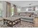 Spacious living room with a plush sofa, ottoman, and area rug at 12428 Chaya Ct, Spring Hill, FL 34610