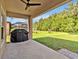 Covered patio featuring a grill and a spacious backyard with lush landscaping at 12428 Chaya Ct, Spring Hill, FL 34610