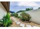 Lush backyard featuring a stone walkway, verdant landscaping, and a tall privacy wall, creating a private oasis at 13544 Avista Dr, Tampa, FL 33624