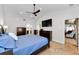 Primary bedroom with vaulted ceilings, travertine floors, and a view of the en-suite bathroom at 13544 Avista Dr, Tampa, FL 33624