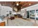 Open concept living room with a wood ceiling, travertine floors, and access to the patio at 13544 Avista Dr, Tampa, FL 33624