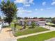 Aerial view of home featuring a lush lawn, mature trees, brick accents, an attached garage, and a fenced yard at 1436 Santa Clara Dr, Dunedin, FL 34698