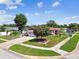 Aerial view of a home with a well-maintained lawn, mature tree, and attached two car garage on a sunny day at 1436 Santa Clara Dr, Dunedin, FL 34698