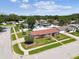 Aerial view of home featuring a lush lawn, mature trees, brick accents, an attached garage, and a fenced yard at 1436 Santa Clara Dr, Dunedin, FL 34698