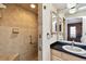 Bathroom with tiled walk-in shower, vanity, and updated lighting at 1436 Santa Clara Dr, Dunedin, FL 34698