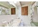 Well-lit bathroom featuring a classic vanity, tiled walls, and a floral shower curtain at 1436 Santa Clara Dr, Dunedin, FL 34698