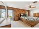 Bedroom with wood paneling, ceiling fan, and sliding glass door to the patio at 1436 Santa Clara Dr, Dunedin, FL 34698