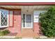 Inviting entryway with brick accents, decorative window lattice, and a secure white security screen door at 1436 Santa Clara Dr, Dunedin, FL 34698
