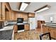 Well-lit kitchen features warm wood cabinets, black countertops and flows to connecting spaces at 1436 Santa Clara Dr, Dunedin, FL 34698
