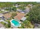 A beautiful backyard pool is surrounded by lush landscaping and a white fence, seen from an aerial perspective at 15005 Roundup Dr, Tampa, FL 33624