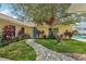 Quaint yellow home with a walkway, lush landscaping, and a charming blue front door at 15005 Roundup Dr, Tampa, FL 33624