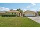 Charming yellow home with a well-manicured lawn and beautiful landscaping at 15005 Roundup Dr, Tampa, FL 33624