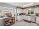 Bright kitchen with white cabinetry, tile floors, stainless steel appliances and abundant natural light at 15005 Roundup Dr, Tampa, FL 33624