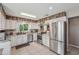 Updated kitchen featuring new appliances, white cabinetry, rustic backsplash and stainless steel fixtures at 15005 Roundup Dr, Tampa, FL 33624