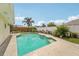 Outdoor pool area with palm trees, lounge chairs, and privacy fence at 15005 Roundup Dr, Tampa, FL 33624