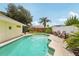 Backyard view of the pool with poolside seating and well-maintained landscaping at 15005 Roundup Dr, Tampa, FL 33624