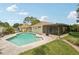 Backyard oasis featuring a sparkling pool, lush landscaping, and a covered lanai at 15005 Roundup Dr, Tampa, FL 33624