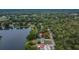 Aerial view featuring a lakefront home with expansive tree coverage and neighborhood at 16112 N 15Th St, Lutz, FL 33549