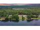 An aerial view highlights the property's lakefront location, surrounded by dense trees and tranquil waters at 16112 N 15Th St, Lutz, FL 33549