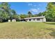 Spacious backyard with a well-maintained lawn, storage sheds, and the home's rear facade at 16112 N 15Th St, Lutz, FL 33549